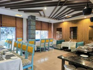 a dining room with tables and chairs in a restaurant at Hotel Shiva Continental in Mussoorie