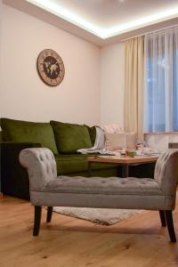 een woonkamer met een groene bank en een tafel bij Apartman Spas Titova Vila Zlatibor in Palisat