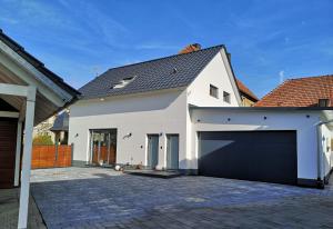 una casa bianca con un ampio garage di FeWo Rügshofen a Gerolzhofen