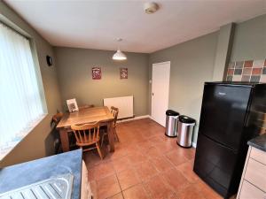 cocina con mesa de madera y nevera negra en 3 Bedroom Apartment Coventry - Hosted by Coventry Accommodation, en Coventry