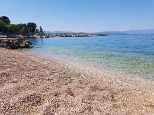 a beach with blue water and a rocky shore at Relax Zone III in Malinska