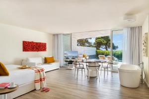a bedroom with a bed and a table and chairs at ME Ibiza - The Leading Hotels of the World in Santa Eularia des Riu