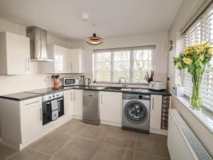 a kitchen with a washing machine and a washer at Paddock View Cottage in Grantham