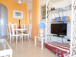 sala de estar con TV y mesa con sillas en Estepona primera línea de playa, apartamento 2-4 personas, en Estepona