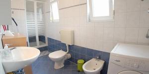 łazienka z umywalką i toaletą oraz umywalką w obiekcie Apartment in Medulin with Terrace, Air conditioning, Wi-Fi, Washing machine (3479-1) w Medulinie