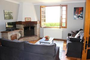 uma sala de estar com dois sofás e uma lareira em Maison de 3 chambres avec vue sur la ville et jardin clos a Langogne em Langogne