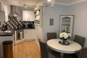 a kitchen and dining room with a table with flowers on it at The Mowbray in Harrogate