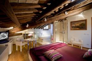 ein Schlafzimmer mit einem Bett und einem Tisch in einem Zimmer in der Unterkunft Gigli D'Oro Suite in Rom