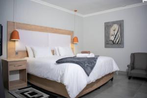 a bedroom with a large bed and a chair at Bergsig Guesthouse in Bethlehem +16 photos