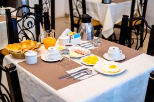 a breakfast table with eggs and bread and orange juice at Hotel Machupicchu Inn in Machu Picchu