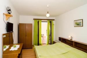 Un dormitorio con una cama verde y una mesa en Villa Barbara, en Mlini