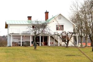 uma casa branca com um telhado verde em Mamma Carinas Pensionat B&B em Bankeryd