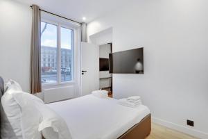 biała sypialnia z łóżkiem i oknem w obiekcie Pick A Flat's Apartment in Neuilly sur Seine - Avenue Charles de Gaulle w mieście Neuilly-sur-Seine