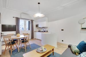 a living room with a table and a kitchen at Pick A Flat's Apartment in Neuilly sur Seine - Avenue Charles de Gaulle in Neuilly-sur-Seine