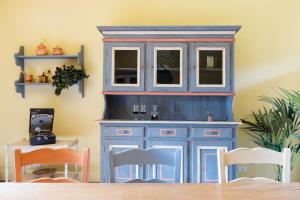 a blue cabinet in a dining room with two chairs at Podere Vignola in Pontassieve