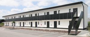 a large white building with a black roof at MEN Hotel by WMM Hotels in Mengen