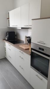 a kitchen with white cabinets and a stove top oven at Goethe 2 - Mitten im Zentrum von Schwerin in Schwerin