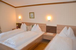 a bedroom with two beds with white pillows at Landgasthof Reitsamerhof in Werfen