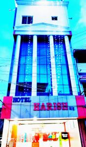 un grand bâtiment avec un panneau devant lui dans l'établissement Hotel Harish, à Rameswaram