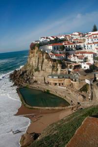 a village on a cliff next to the ocean at Sonho do Poeta in Sintra