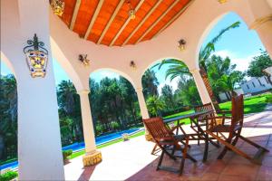 蒙特羅伊格的住宿－Villa Balneari Resort Casa de vacances familiar，一个带椅子的门廊,享有游泳池的景色