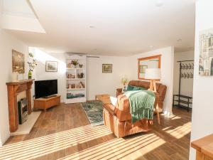 a living room with a couch and a television at Oak Cottage in Sheffield