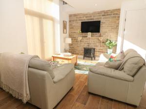 a living room with two chairs and a fireplace at Holly Cottage in Sheffield