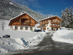 a chalet in the snow with a road in front at Agriturismo La Flu in San Martino in Badia