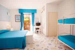 sypialnia z 2 łóżkami piętrowymi i biurkiem w obiekcie Hotel Residence Villa San Giovanni w mieście Portoferraio