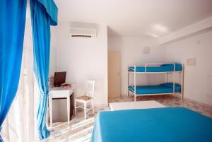 Schlafzimmer mit einem blauen Bett und einem Schreibtisch in der Unterkunft Hotel Residence Villa San Giovanni in Portoferraio
