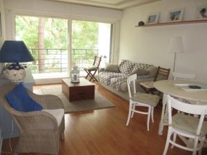 een woonkamer met een bank en een tafel bij Appartement Pour 4 Personnes- Residence Sporting House in Hossegor