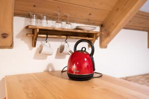 a red tea kettle sitting on top of a table at Penzion V Poli in Klimkovice
