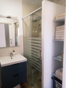 a bathroom with a glass shower and a sink at The Blue Family House in Cabo de Palos