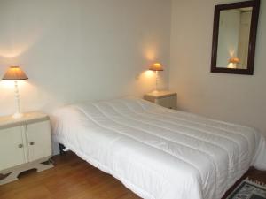 een slaapkamer met een groot wit bed met 2 lampen bij Appartement Pour 4 Personnes- Residence Sporting House in Hossegor
