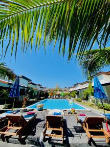 a swimming pool with lounge chairs and umbrellas at YinDee Lanta Villas in Ko Lanta