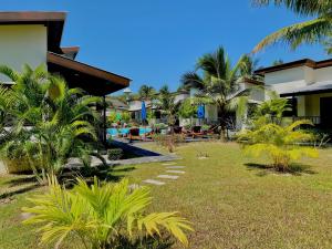 a resort yard with palm trees and a pool at YinDee Lanta Villas in Ko Lanta