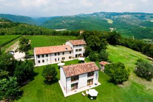 une vue aérienne sur une maison sur une colline avec un vignoble dans l'établissement Tenuta Delo Relais, à Novaglie