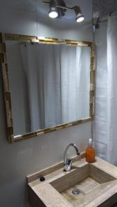 un lavandino da bagno con un grande specchio sopra di Cabañas Abril a Zonda