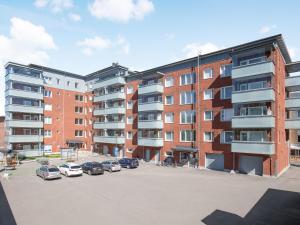 un complejo de apartamentos con coches aparcados en un aparcamiento en Kansankatu Apartments, en Rovaniemi