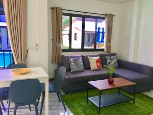 un soggiorno con divano e tavolo di YinDee Lanta Villas a Ko Lanta