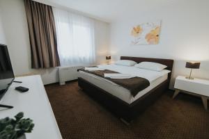Habitación de hotel con cama y escritorio en Hotel Brcko Gas Doboj, en Doboj