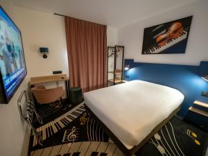 A bed or beds in a room at Welcomotel Beauvais Aéroport