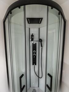 a glass shower with a phone in it at Welcomotel Beauvais Aéroport in Beauvais