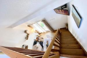 - un escalier dans une maison revêtue de parquet dans l'établissement Maisonnette de charme Bord de mer Piscine, à Guidel
