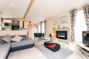 a living room with a couch and a tv at Meadows Lodge with Hot Tub in Malton