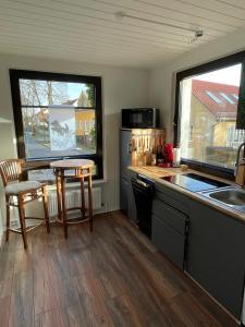 a kitchen with a counter and two windows and a table at Appartement Seebadallee mit Wallbox für e-Autos in Rangsdorf