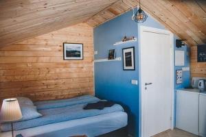 a bed in a room with a wooden wall at Rauðuskriður farm in Hólmabæir