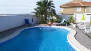 Młoda dziewczyna stoi na skraju basenu. w obiekcie VILLA DOS-LAGOS w mieście Torrevieja