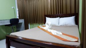 a hotel room with a bed with towels on it at Amazon Resort in Suratthani