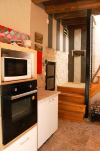 eine Küche mit einer Mikrowelle und einem Herd in der Unterkunft Sonho do Poeta in Sintra
